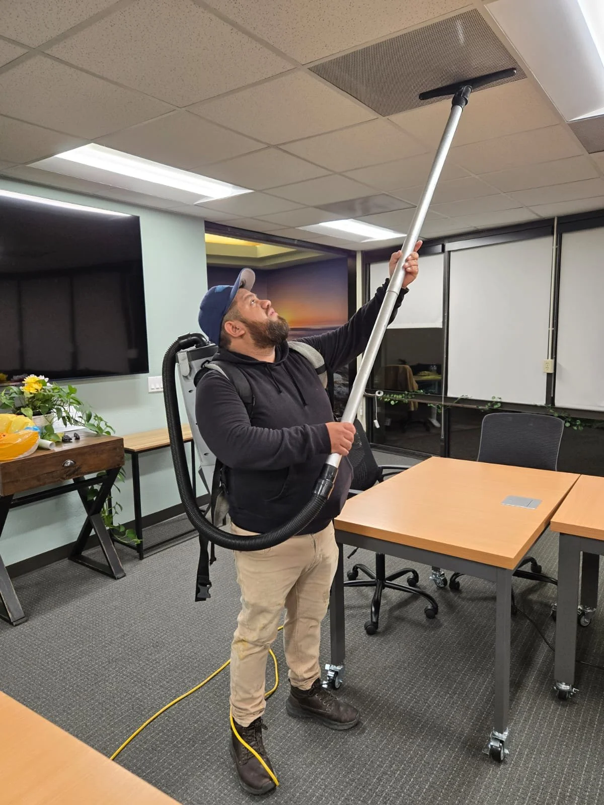 Oracle Group Services technician cleaning office ceiling vents in San Diego